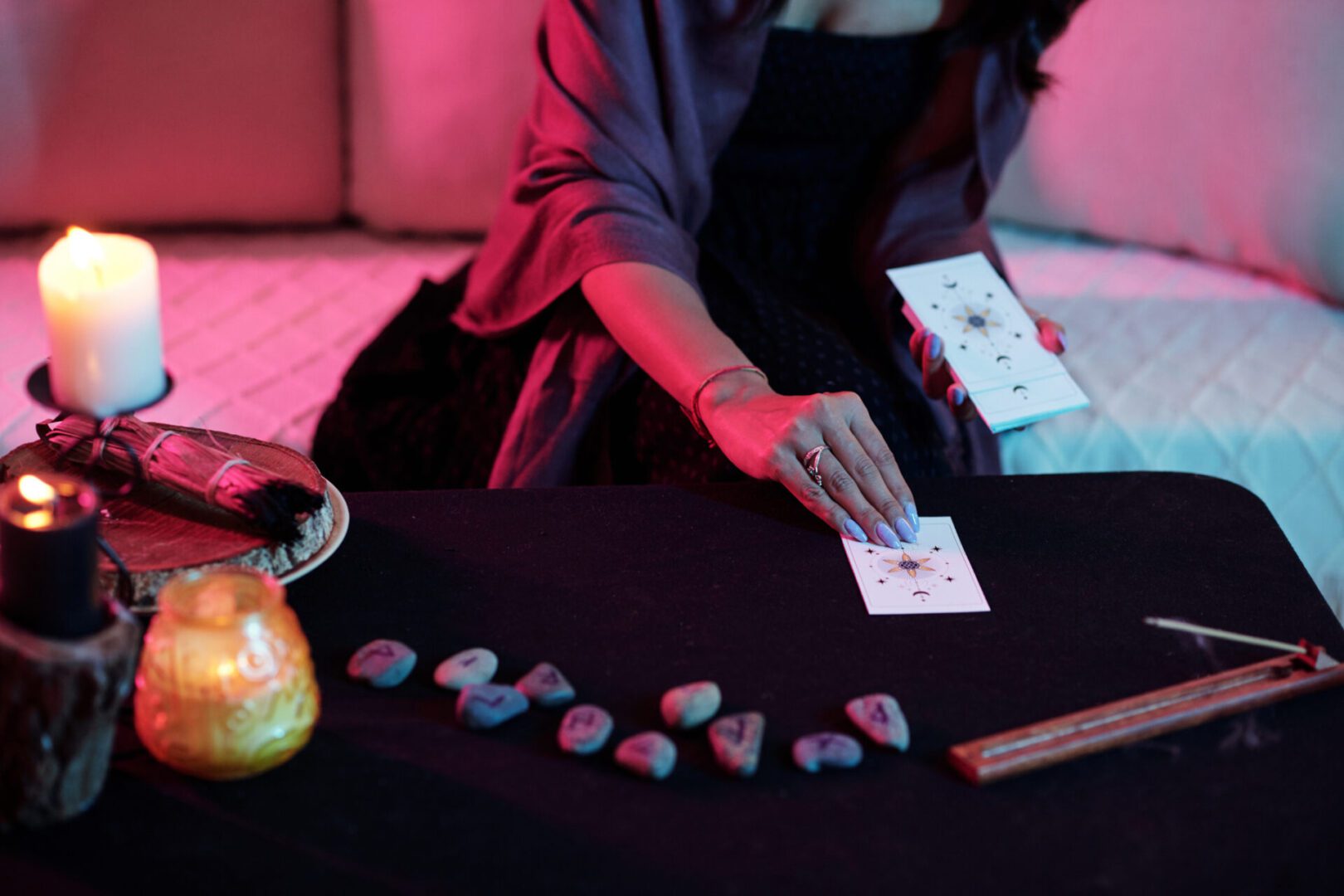 Hands of young woman laying out tarot cards to read future